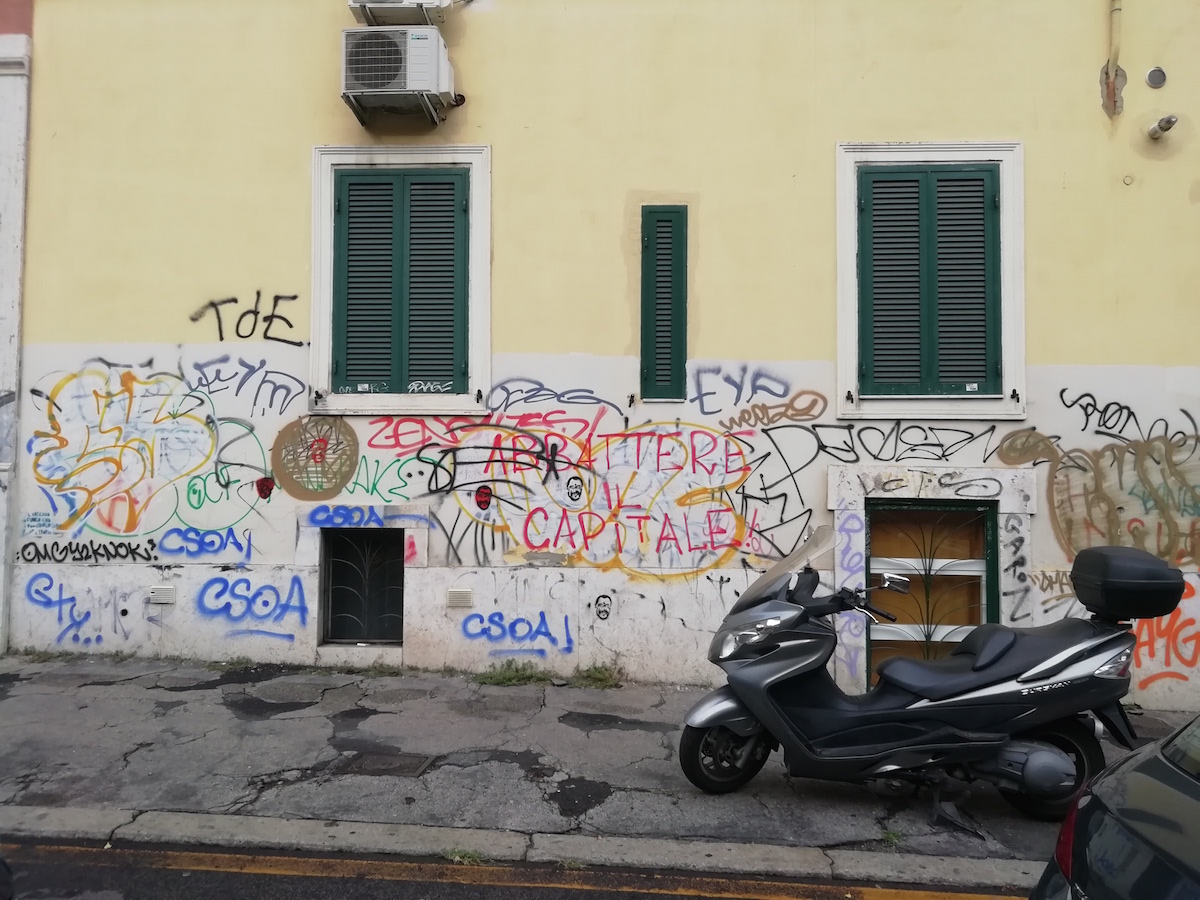 Scritte in via dei Marrucini comparse sulla porzione della parete che è stata ridipinta