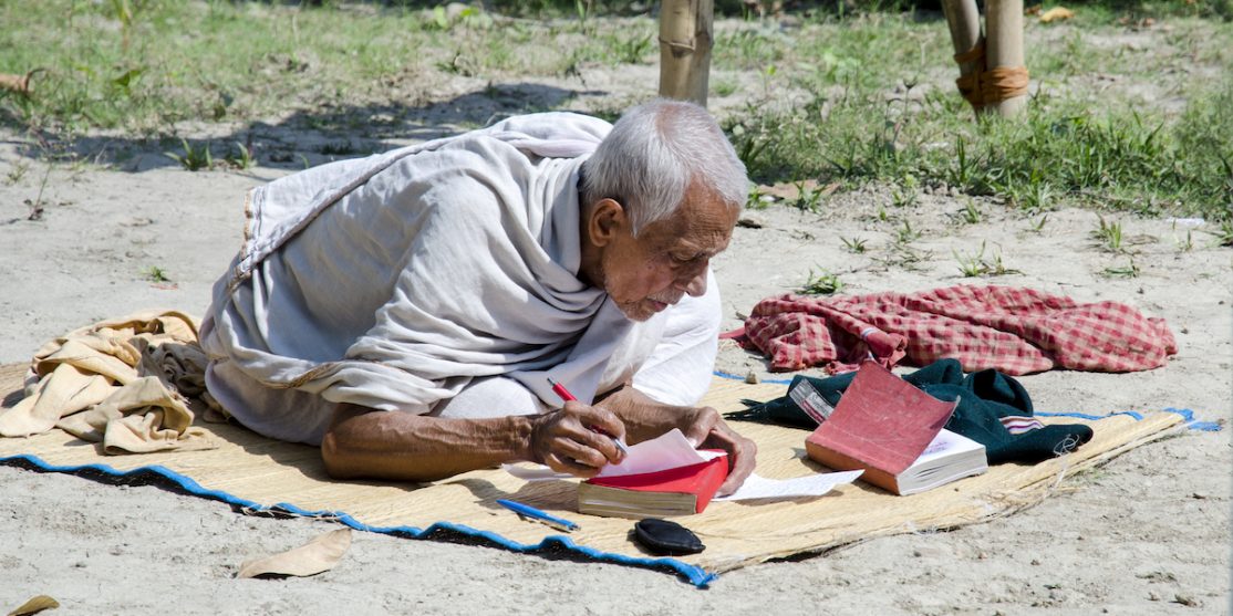 Elderly_Person_Reading_on_the_Street_of_Baranagar_01